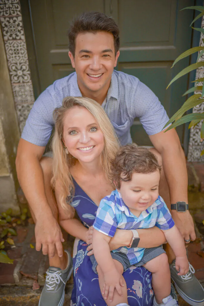 Smiling family of three on front steps