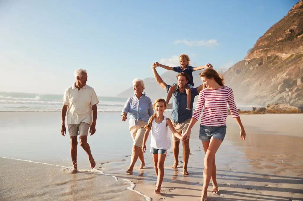 Multigenerational family walking on sunny beach