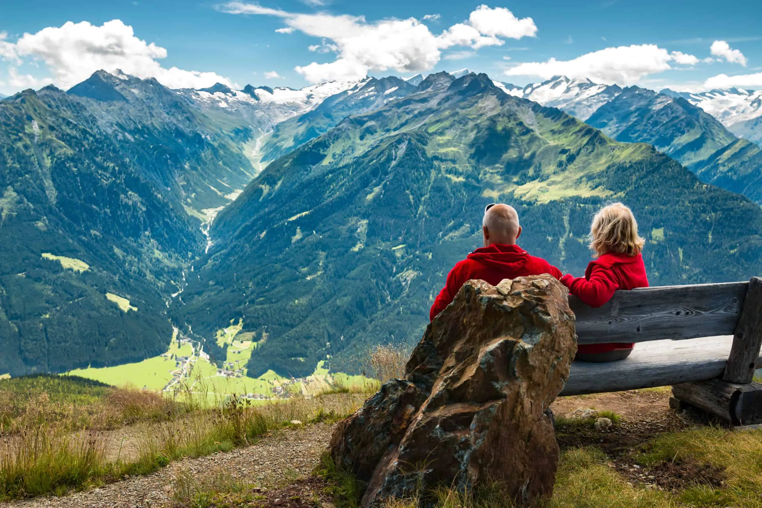 Couple on bench overlooking alpine mountain valley